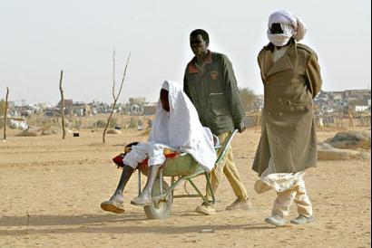 eldrly_sudanese_transported_on_a_wheelbarrow.jpg