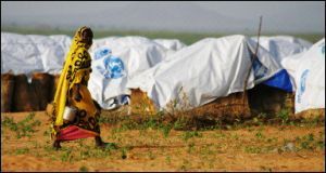 woman_walks_through_a_refugee_camp.jpg