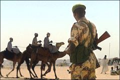 Camel_riders_pass_in_front_of_a_Rwandan.jpg