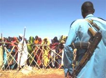 Sudanese_policeman_watches_displaced.jpg