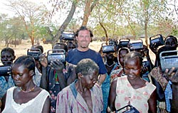 Undated Photo of John Granville with South Sudanese people holding up radios (USAID)