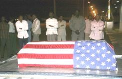 Sudanese men look at the flag-draped coffin of U.S. diplomat John Granville, 33, who worked for the USAID, as it is received by U.S. officials in Khartoum, Jan. 3, 2008. (AP)