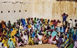 Refugees who fled the conflict in Sudan's western Darfur region wait outside an aid distribution building at Djabal camp near Gos Beida in eastern Chad June 12, 2008 (Reuters)