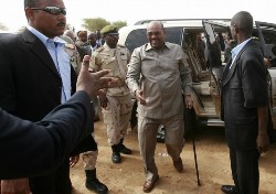 Surrounded by security, Sudanese President Omar al-Beshir (C) is greeted by officials upon his arrival at El-Fasher in north Darfur on July 23, 2008 (AFP)