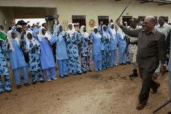 Sudanese President Omar al-Beshir raises his cane in greeting as he visits a girl's high school in South Darfur's state capital Nyala on July 24, 2008 (AFP)