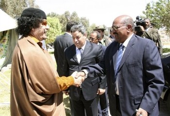 Libyan leader Moammar Gadhafi greets Sudanese President Omar Al-Bashir, right, upon his arrival in Tripoli, Libya, Thursday, March 26, 2009 (AP)