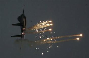 An Israeli Air Force fighter plane releases flares during an aerobatics display at a graduation ceremony for new pilots at the Hatzerim Air Force Base near the southern Israeli city of Beersheba (AP)