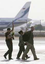 Rescued unidentified former hostages wave to journalists after arriving at the East Cairo Military Airport in Cairo, Egypt Monday, Sept. 29, 2008 (AP)