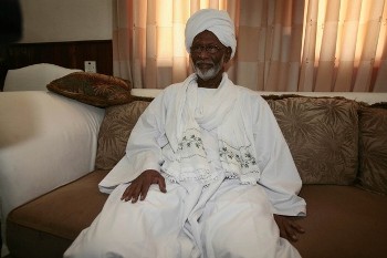 Islamist opposition leader Hassan al-Turabi, 76, sits on a couch at his house in Khartoum (Reuters)
