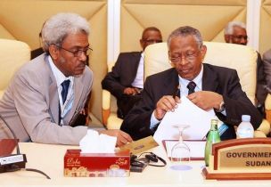 Sudanese presidential adviser Nafi Ali Nafi (R) and Amin Hassan Omer attend a Darfur peace talks meeting with the rebel Justice and Equality Movement in Doha, February 10, 2009 (Reuters)