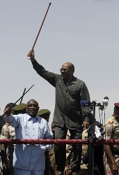 Sudanese President Omer Al-Bashir (R) waves his cane to supporters during his visit to the North Darfur state capital of el-Fasher on March 8, 2009 (AFP)