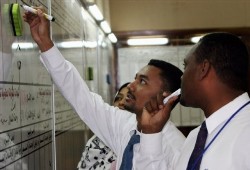 Stockbrokers inspect prices at the Sudan Stock Exchange in the capital Khartoum, Sudan (AP)
