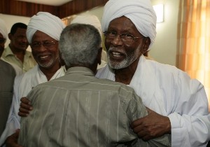 Islamist opposition leader Hassan al-Turabi (R), 76, hugs his follower at his house in Khartoum March 9, 2009 (Reuters)