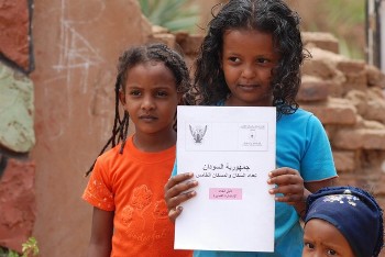 A Sudanese girl holds the guide of Sudan's 5th Population and Housing Census outside her home in the Sudanese capital Khartoum on April 22, 2008 (AFP)