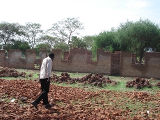 Rumbek Central County Commissioner Abraham Makoi Bol Kodi walks toward a school under construction (photo M. Mayom)