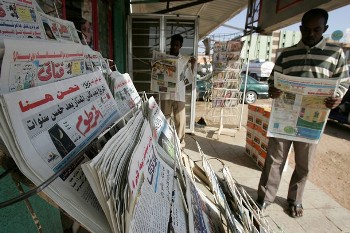 Sudanese men read sports news in the absence of ten political newspapers in Khartoum on November 18, 2008 (AFP)