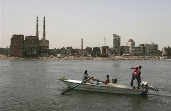 A family of fishing people, with from left to right, Um Ahmed and her grandsons, Mohammed Ibrahim and Adel Ibrahim as they work in their boat on the Nile river in Cairo, Egypt (AP)