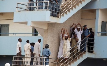Four Sudanese convicts lift their handcuffs as they are escorted out of the courtroom in the capital Khartoum, June 24, 2009 (Reuters)