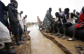 Sudanese gather in a flooded area following torrential rains in the capital Khartoum, Sudan, Wednesday, Aug. 26, 2009 (AP)