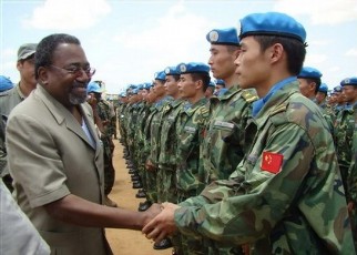 Rodolphe Adada, left, greets members of the Chinese follow-up troop of engineering unit after their arrival in Nyala, the capital of South Darfur state of Sudan, Thursday, July 17, 2008 (AP)