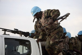 A Nigerian peacekeeping soldier from the United Nations-African Union Mission in Darfur (UNAMID) jumps from a vehicle while on patrol in Osha IDP's camp in Nyla, southern Darfur (Reuters)
