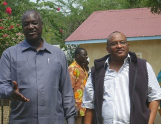 Gov. Kuol Manyang Juuk (L) and Ashraf Ahmed (R) share a light in Bor (Photo Philip Thon)