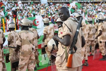 Sudanese policemen stand guard in front of Algerian fans ahead of the 2010 World Cup qualification play-off between Egypt and Algeria in Khartoum on November 18, 2009 (AFP)