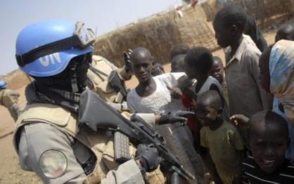 An Indonesian police officer talks to children as he patrols Zamzam refugee camp in North Darfur Feb 8, 2010. (Reuters)