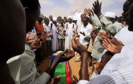 Relatives and students pray during the burial of Darfuri student Mohamed Moussa in Omdurman , February 15, 2010. His body was covered with the SLM flag  (Reuters)