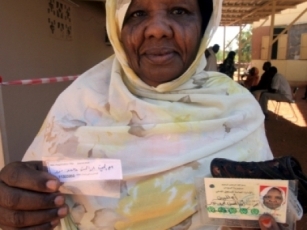 A woman displays her identity card after registering for Sudan's elections (Reuters)