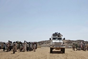 An armoured personnel carrier manned by South African soldiers serving with the UNAMID drives through the village of Kafod in North Darfur during a patrol through the region. (photo by UN)
