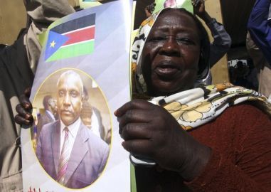 A supporter holds a poster of SPLM presidential candidate Yasir Arman at Khartoum airport January 21, 2010 (Reuters)