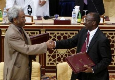 Amin Hassan Omar for Sudanese government (L) and JEM top negotiator Ahmed Tugod exchange framework agreements in Doha February 23, 2010. (Reuters)