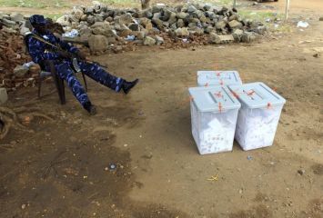 A policeman sits next to ballot boxes at the start of vote counting at a polling station in Juba, south Sudan April 16, 2010. (Reuters)