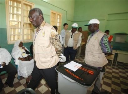 Ghana's former president John Agyekum Kufuor, top delegation of the African Union, left, observes a polling station in Khartoum (AP)