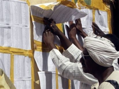 Sudanese check their names on lists outside a polling station to vote for Sudan's first multiparty elections in decades in Khartoum on 11 April 2010 (AP)