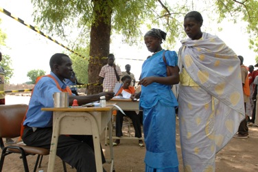 Women check voting information with an official at a polling station in Juba, April 11, 2010. (UNMIS)