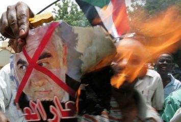 A Sudanese burns a poster of the ICC prosecutor Luis Moreno-Ocampo during a demonstration outside the presidential palace in Khartoum on July 17, 2008