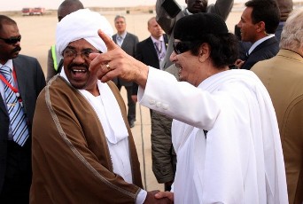 FILE - Libyan leader Moamer Kadhafi (R) greets Sudanese President Omar al-Beshir upon the latter's arrival at the airport in the Libyan coastal city of Sirte on March 26, 2010 (AFP)