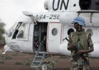 A Rwandan soldier serving with the UNAMID stands next to a UN helicopter in North Darfur  (Photo AFP)