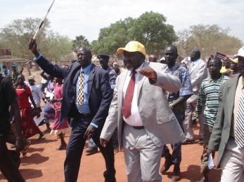 Daniel Ayual Makoi carrying up walking stick during election campaign and Governor Chol Tong Mayay at right (photo by Manyang Mayom)