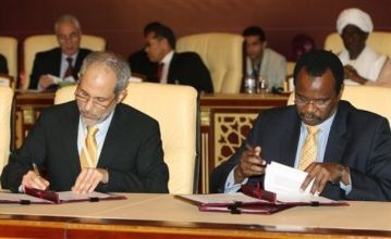 Sudan Presidential adviserGhazi Salah Eddin Atabani, left, and rebel leader Al-Tijani Al-Sissi sign the truce documents in Doha Thursday March 18, 2010 (AP)