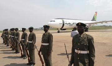 Members of Ugandan army wait as the plane carrying Libyan leader Muammar Gaddafi lands at the airport in Entebbe 42km (25 miles) south of Uganda's capital Kampala, July 24, 2010 (Reuters)