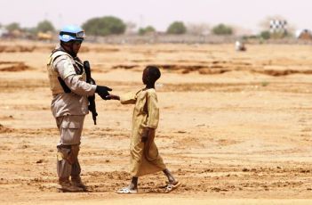 A UN soldier shakes hands wit a young boy in El-Fasher, the capital of North Darfur on July 5, 2010 (Getty)