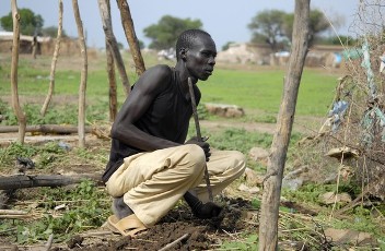 FILE - A man squats on the foundation of a house destroyed during fighting in Abyei town, central Sudan, July 8, 2009 (Reuters)