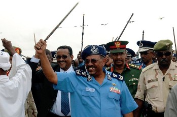 Sudanese President Omer al-Bashir wearing the police uniform and waving his trademark cane, attends a ceremony honouring the Sudanese police force in Khartoum on July 20, 2010 (AFP)