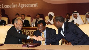 FILE - Ghazi Salah Al-Deen Al-Attabani (L), adviser to Sudan's President Omar Hassan al-Bashir, shakes hands with and UN negotiator on Darfur Djibril Bassole (R) next to Al-Tijani Al-Sissi of the Liberation and Justice Movement (LJM) in Doha on March 18, 2010 (AFP)