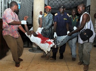 An injured man is carried in Kampala's Mulago hospital, on July 12, 2010 after twin bomb blasts tore through crowds of football fans watching the World Cup final (AFP)
