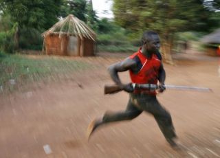 A member of a local self defense force runs in the village of Bangadi in northeastern Congo, February 18, 2009. (Reuters)