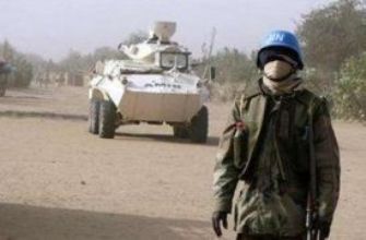 An African Union-U.N. soldier stands in front of an old African Union APC during a patrol in West Darfur in El-Geneina February 19, 2008. (UNAMID)